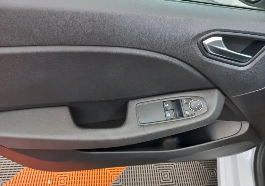 Gros plan sur la porte côté conducteur noire de la Renault Clio Business blanche, avec commandes électriques des vitres et rétroviseurs.