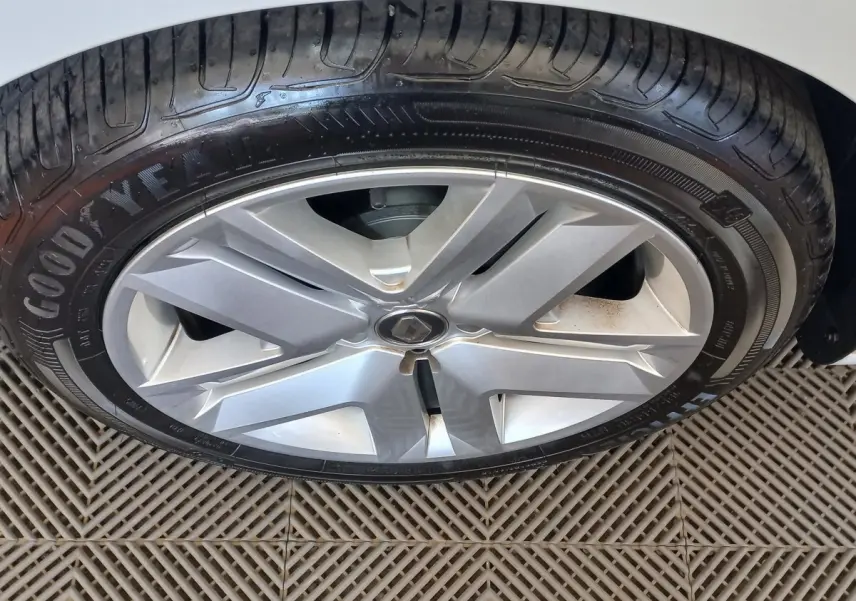 Gros plan sur la roue avant droite d'une Renault Clio blanche avec jante alliage et pneu Goodyear.