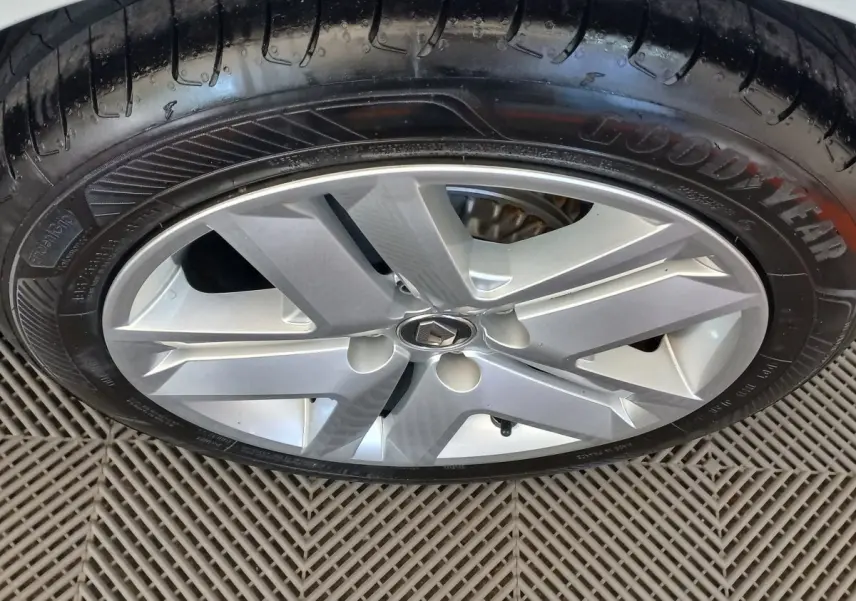 Gros plan sur la jante argentée et le pneu Goodyear d'une Renault Clio Business blanche, vue côté roue.