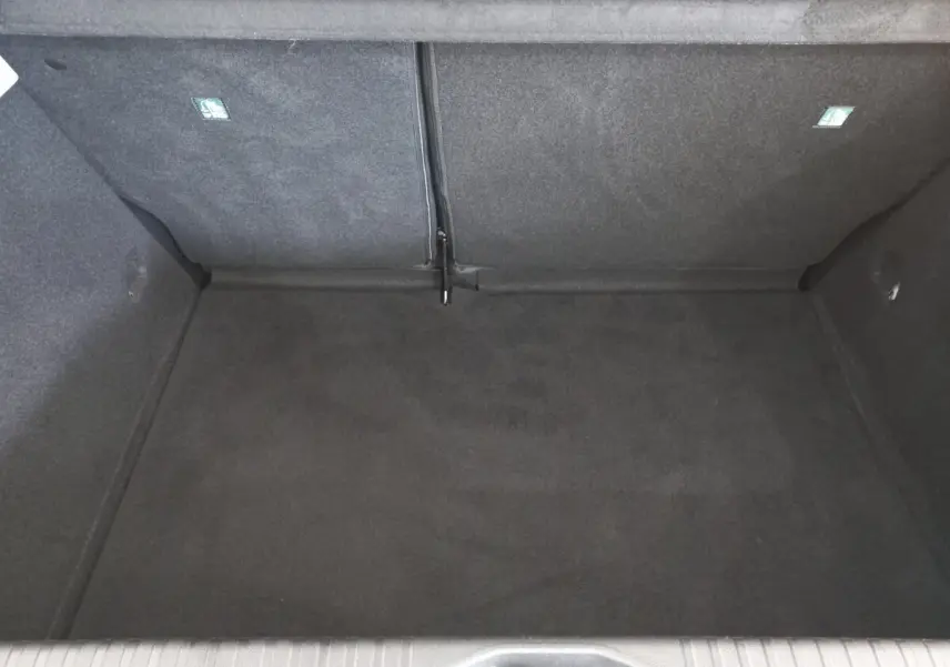 Coffre vide de Renault Clio Business blanc, vue plongeante sur l'espace de chargement avec banquette rabattue.