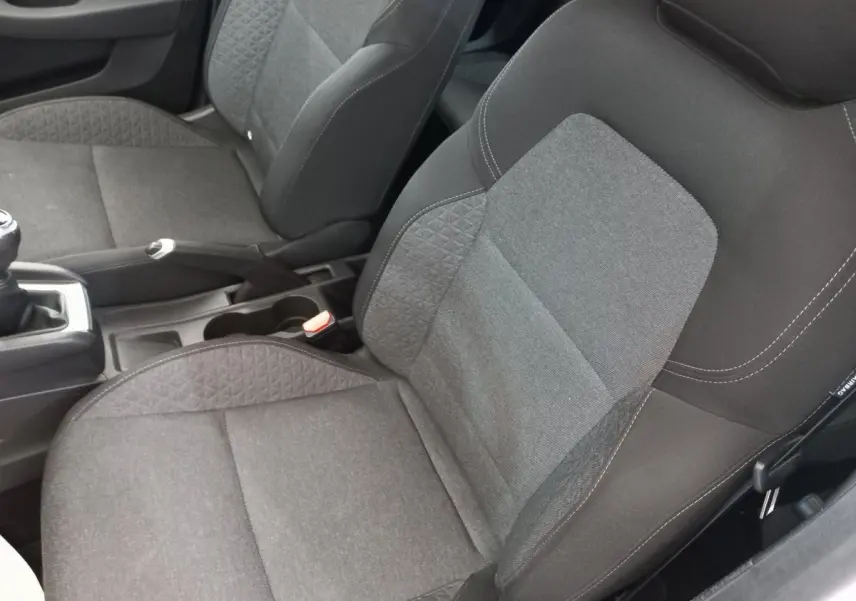 Vue rapprochée des sièges avant gris foncé de la Renault Clio Business SCe 65 blanche, avec levier de vitesse manuel visible.