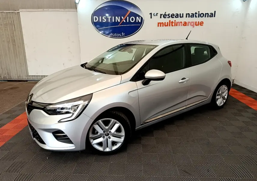 Renault Clio Business E-Tech hybride gris clair vue 3/4 avant droit, feux LED et jantes alliage visibles en intérieur showroom