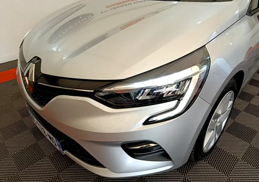 Vue 3/4 avant droit d'une Renault Clio Business E-Tech hybride 2021 gris clair avec phares LED et calandre noire.