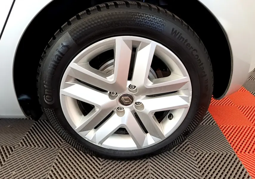 Gros plan sur la roue arrière droite d'une Renault Clio Business E-Tech hybride gris clair, avec partie de la carrosserie visible.