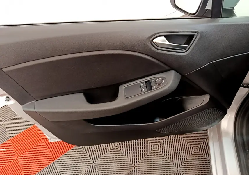 Gros plan sur la porte avant gauche gris clair de la Renault Clio Business E-Tech hybride avec commandes électriques des vitres.