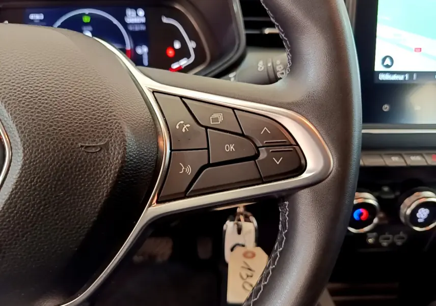 Gros plan sur le volant noir de la Renault Clio Business E-Tech hybride 2021 avec commandes multifonctions visibles.