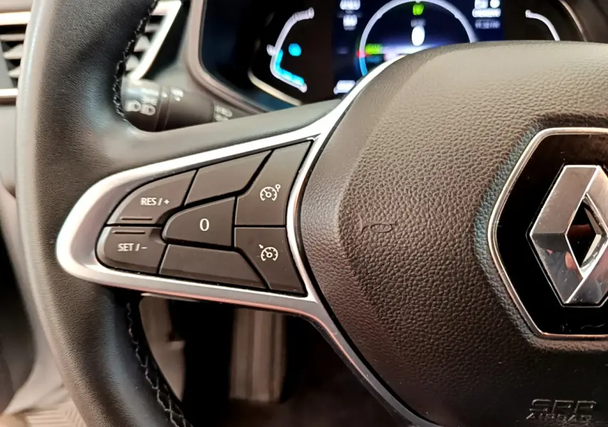 Gros plan sur le volant cuir noir de la Renault Clio Business E-Tech hybride 2021 avec commandes intégrées et logo central.