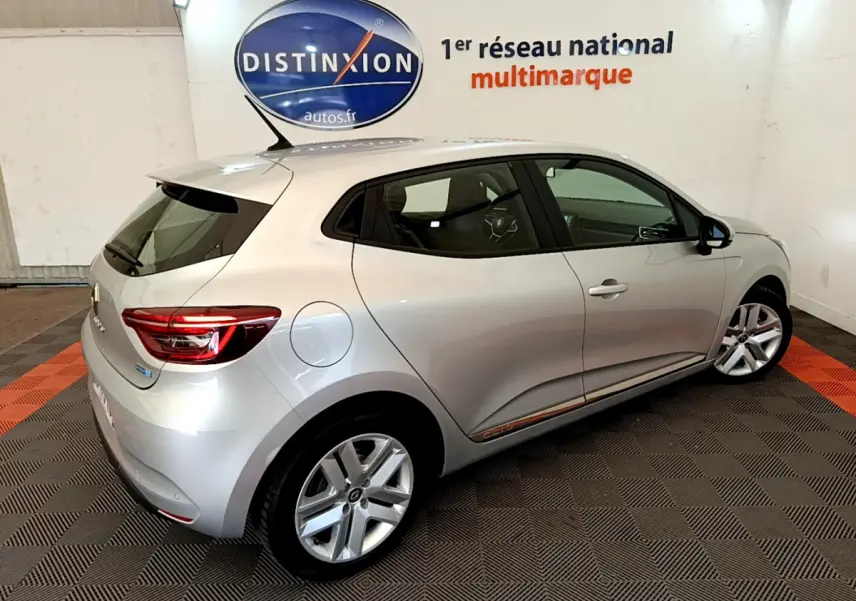 Renault Clio Business E-Tech hybride gris clair vue 3/4 arrière droit en intérieur showroom avec logo Distinxion.