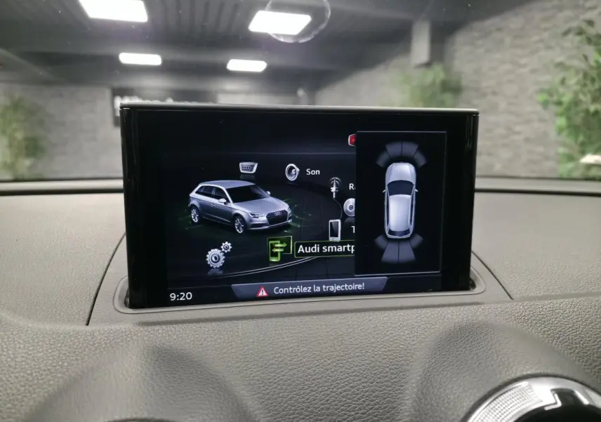 Écran central affichant l'interface Audi smartphone dans un Audi A3 Sportback gris, vue intérieure tableau de bord.