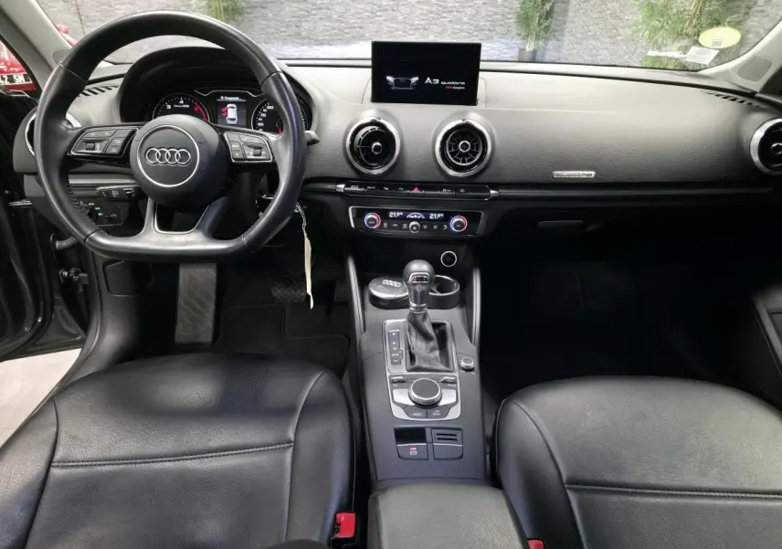 Intérieur noir de l'Audi A3 Sportback 2017, vue de face sur le tableau de bord et le volant multifonction.