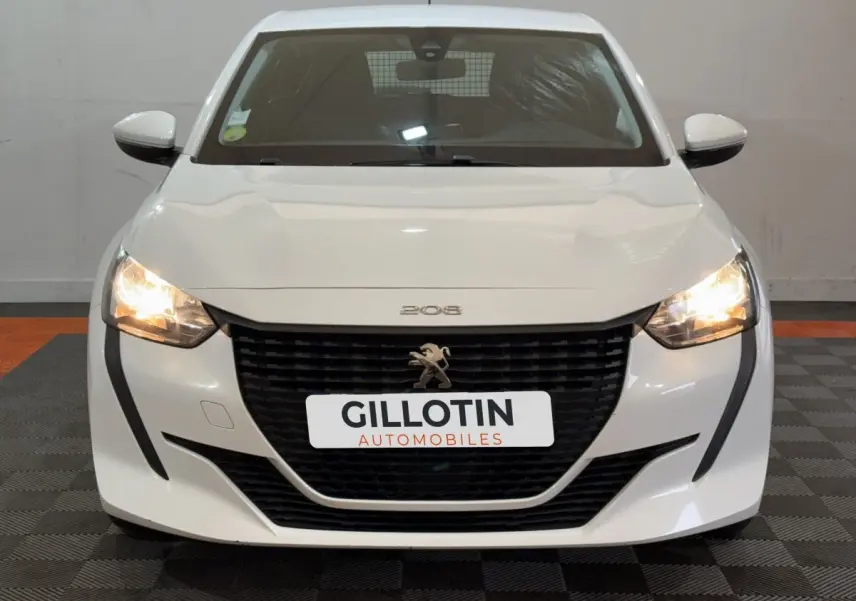 Vue frontale d'une Peugeot 208 blanche de 2021 avec phares allumés et calandre noire distinctive.