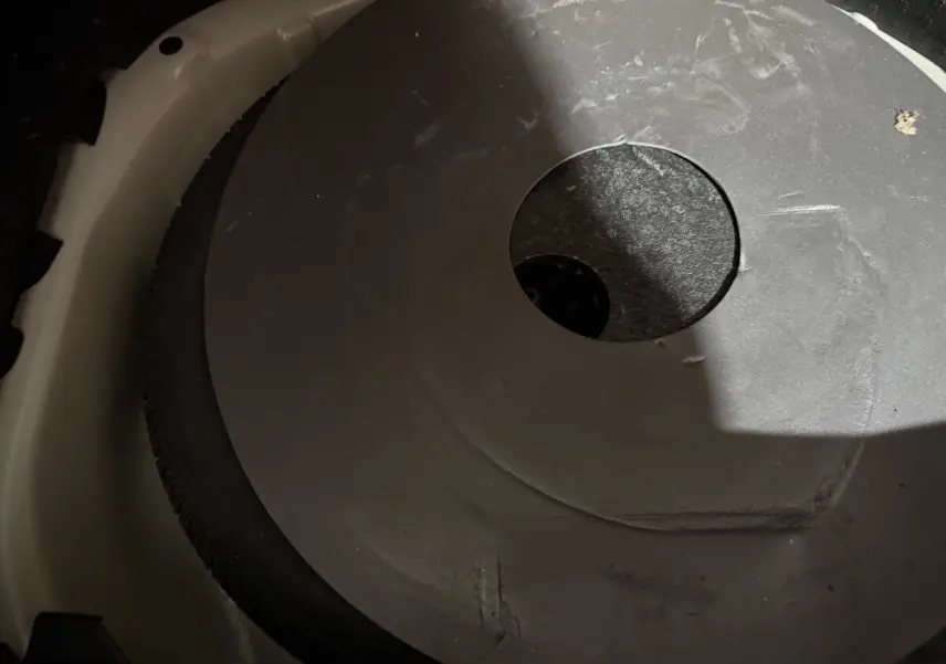 Gros plan sur la roue de secours noire dans le coffre blanc d'une Peugeot 208 1.5 BlueHDi 2021.