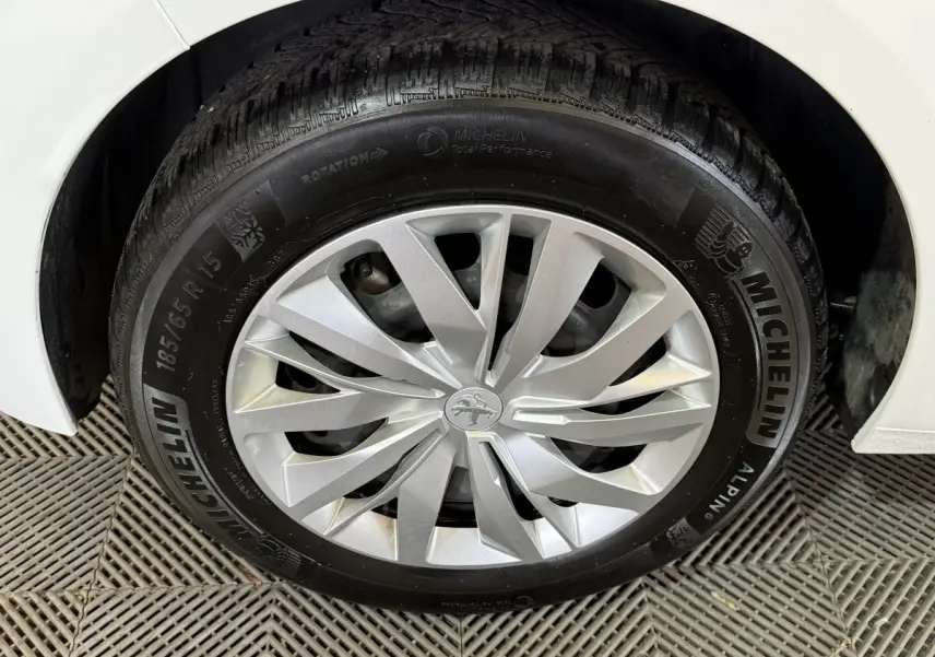 Gros plan sur la roue avant droite blanche d'une Peugeot 208 1.5 BlueHDi avec jante argentée et pneu Michelin.