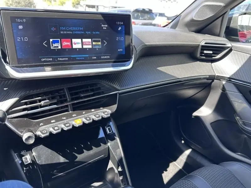 Vue intérieure côté passager du tableau de bord de la Peugeot 208 GT Line 2020 avec écran tactile et finitions noires.