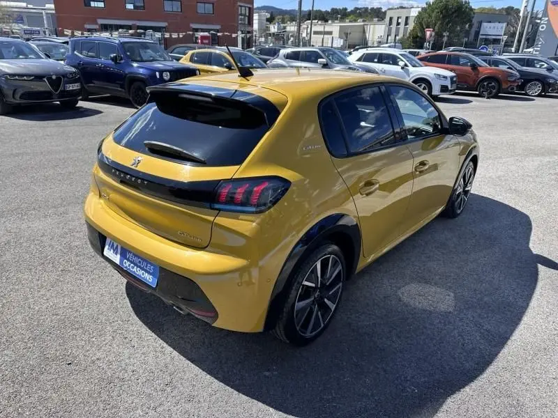 PEUGEOT 208 GT Line jaune faro vue 3/4 arrière droit, avec feux arrière à griffes et jantes alliage noires.
