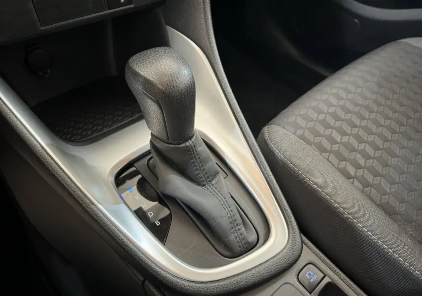 Le levier de boîte automatique noir de la Toyota Yaris hybride 2022 vu en gros plan côté droit avec siège tissu gris.