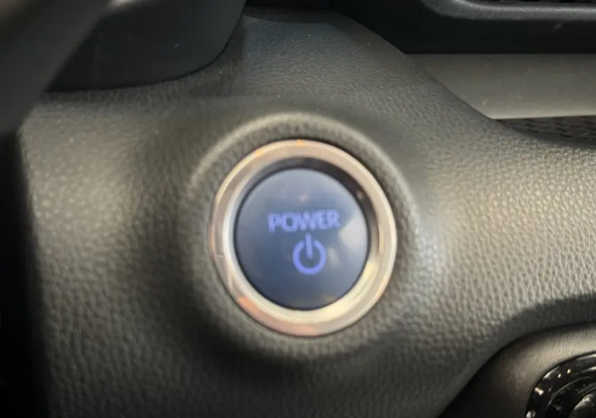 Bouton démarrage Power en gros plan sur tableau de bord noir d'une Toyota Yaris hybride blanche 2022