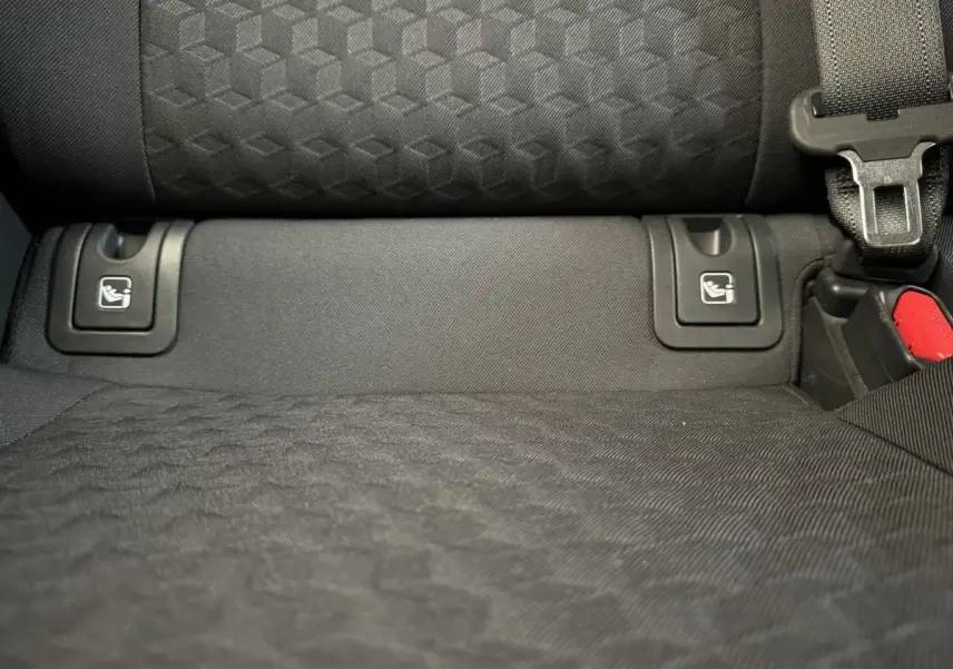 Gros plan sur la banquette arrière noire de la Toyota Yaris hybride 2022 avec fixations Isofix visibles et ceinture de sécurité.