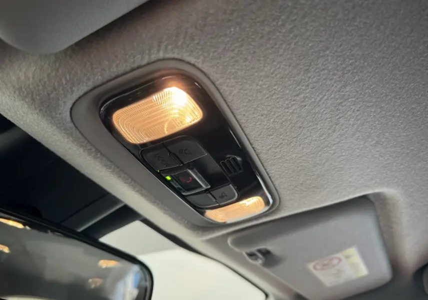 Plafonnier intérieur allumé avec commandes SOS et éclairages de lecture dans une Toyota Yaris blanche hybride 2022