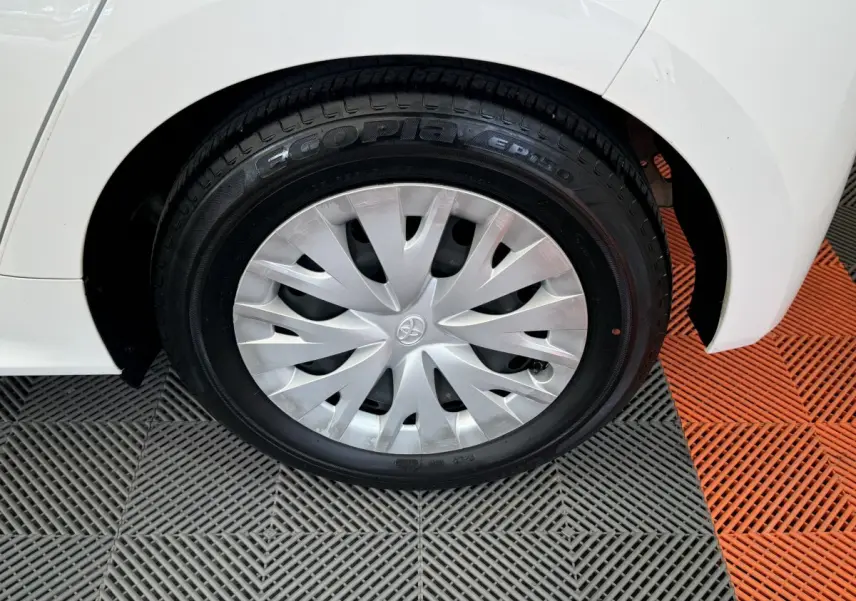 Gros plan sur la roue arrière droite blanche d'une Toyota Yaris hybride 2022 avec enjoliveur argenté et pneu Ecopia.