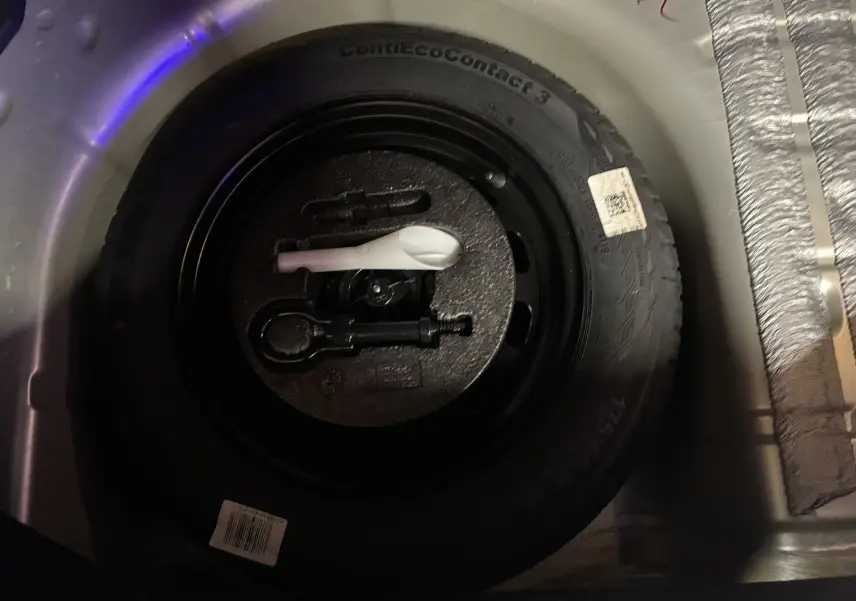 Gros plan sur la roue de secours et les outils de bord dans le coffre d'une Ford Fiesta gris 2020.