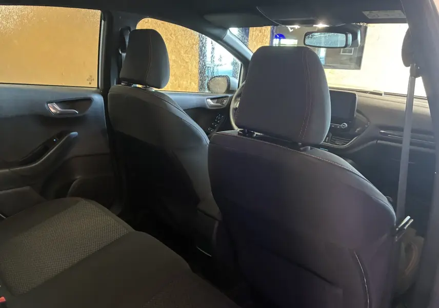 Vue intérieure de la Ford Fiesta 1.0 EcoBoost 95 ST Line 2020, montrant les sièges avant et arrière en tissu gris noir.