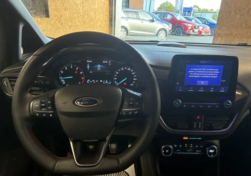 Vue intérieure du tableau de bord et volant Ford Fiesta 2020 gris, avec écran tactile et commandes au volant visibles.