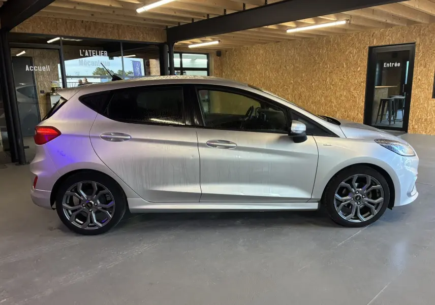 Ford Fiesta 1.0 EcoBoost 95 ST Line gris vue de profil côté gauche, avec jantes alliage et vitres teintées.
