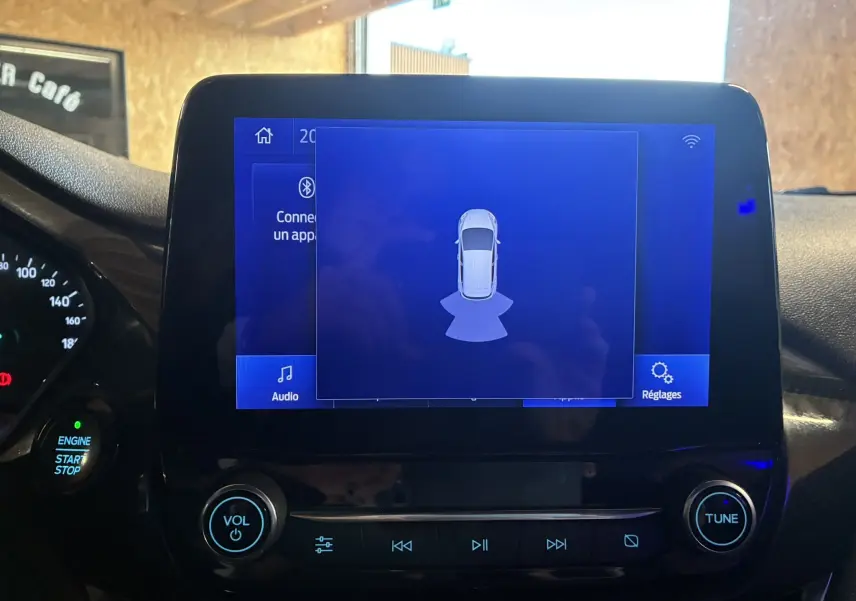 Écran tactile central de la Ford Fiesta gris 2020 montrant l'interface de détection de proximité avec commandes audio et réglages visibles.