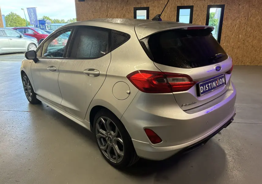 Vue 3/4 arrière droite d'une Ford Fiesta gris métallisé 2020 avec jantes alliage et vitres teintées dans un garage.