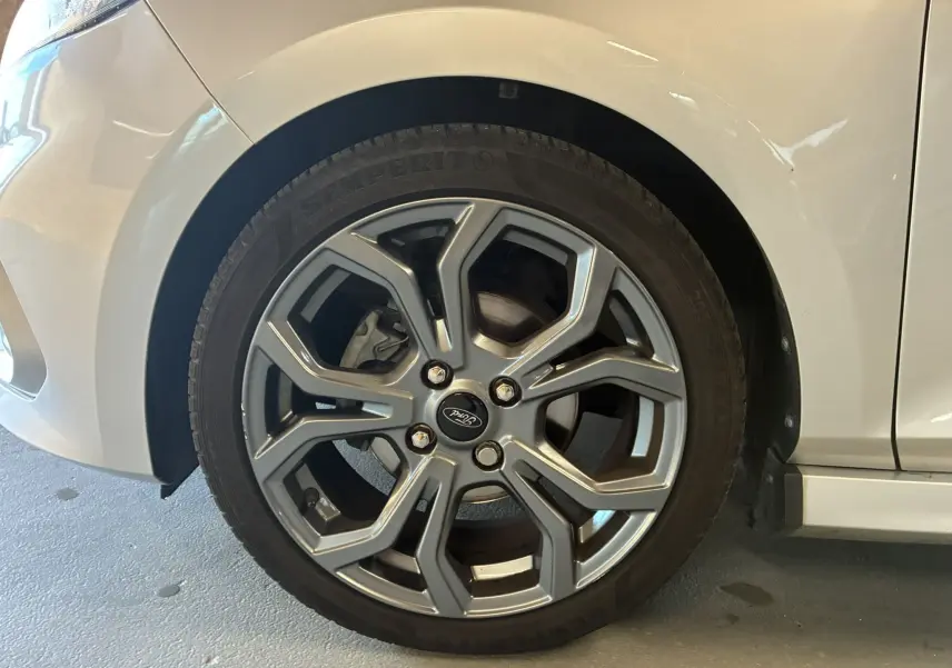 Gros plan sur la roue avant gauche grise d'une Ford Fiesta 1.0 EcoBoost 95 ST Line avec jante alliage distinctive.