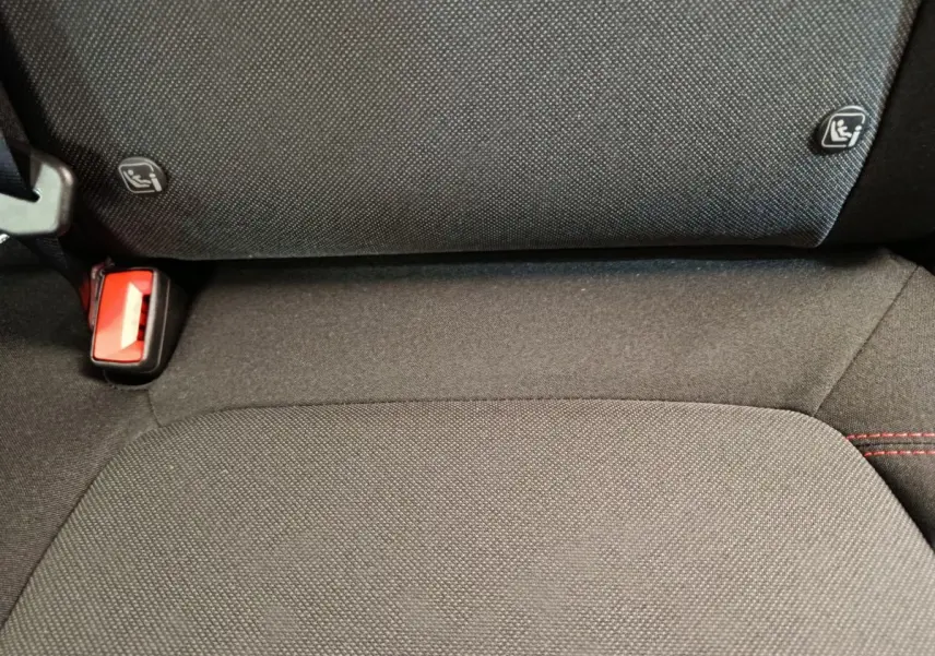 Gros plan sur la banquette arrière noire du Ford Puma 2025 avec fixation Isofix et ceinture rouge visible.