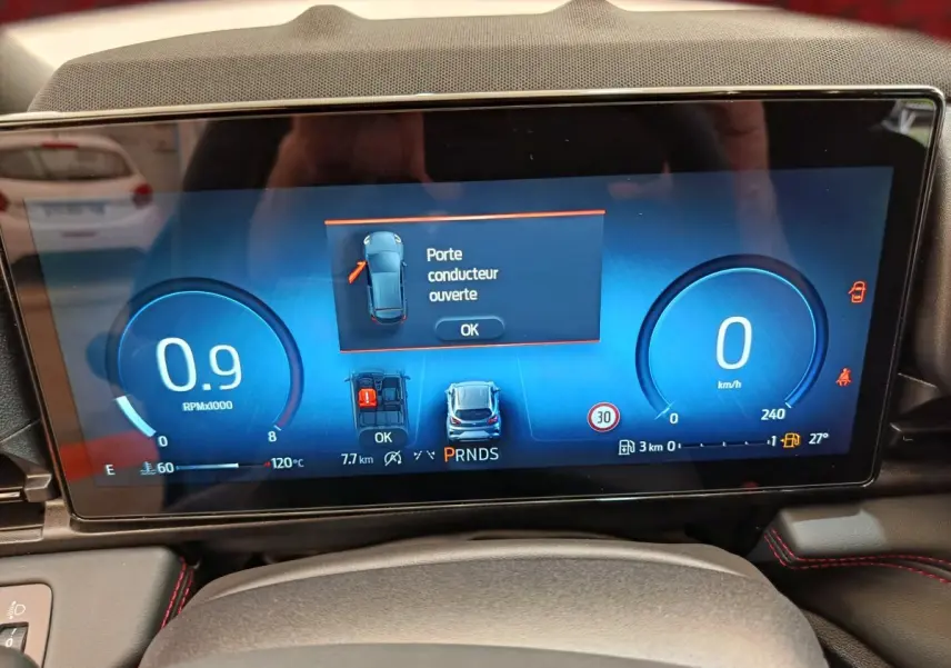 Affichage numérique du combiné d'instruments du Ford Puma bleu, montrant une porte conducteur ouverte et vitesse à zéro km/h.