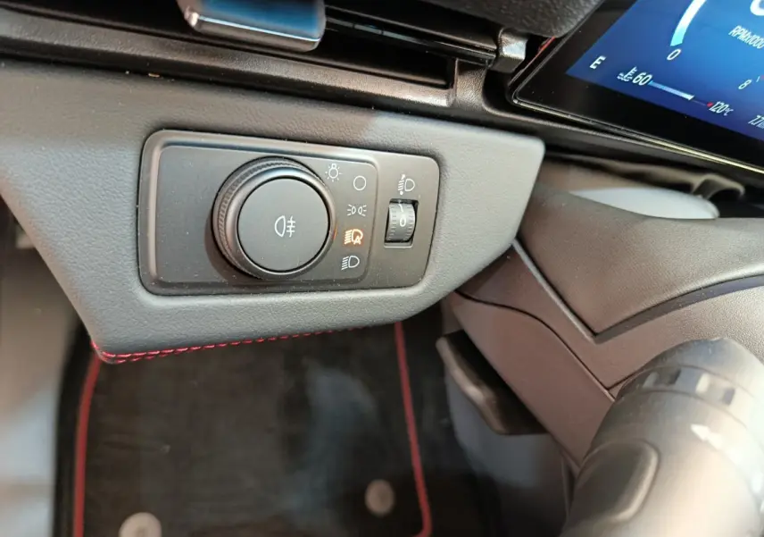 Gros plan sur le panneau de commande des phares à gauche du volant dans l’habitacle du Ford Puma bleu 2025.