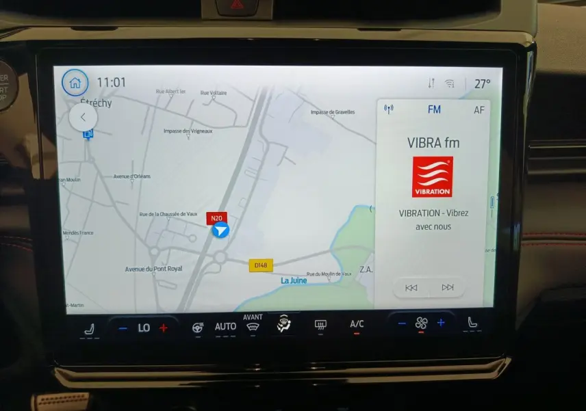 Écran tactile central du Ford Puma 2025 affichant la navigation et la radio VIBRA fm, avec commandes climatisation en dessous.