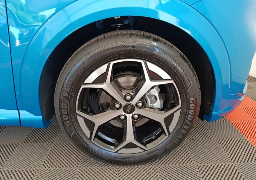 Gros plan sur la roue avant droite du Ford Puma bleu 2025 avec jante alliage et pneu Goodyear visible.