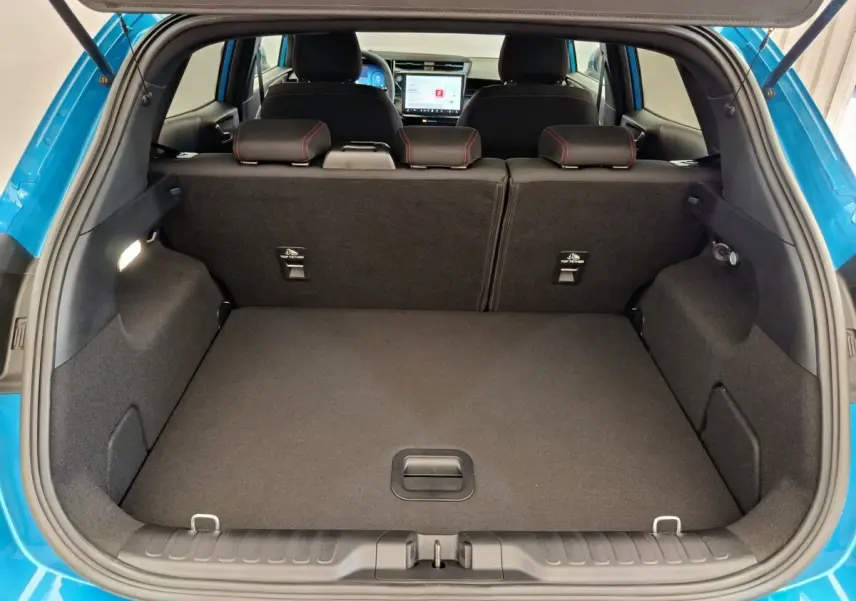 Coffre ouvert du Ford Puma bleu 2025, vue arrière montrant banquette et écran tactile intérieur.