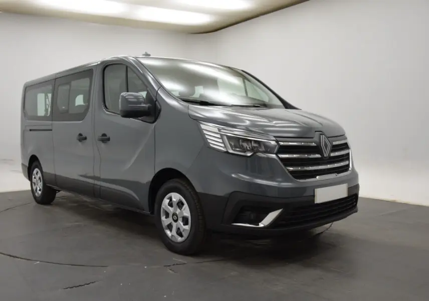 Renault Trafic Fourgon gris clair en 3/4 avant droit, avec calandre chromée et feux LED distinctifs.