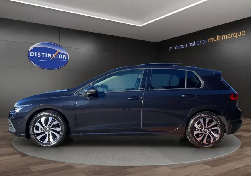 Profil gauche d'une Volkswagen Golf VIII noire nacrée, avec jantes alu 16 pouces et vitres arrière surteintées.