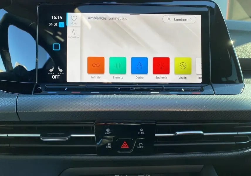Vue rapprochée de l’écran tactile central de la Volkswagen Golf VIII noire, affichant les options d’ambiances lumineuses.