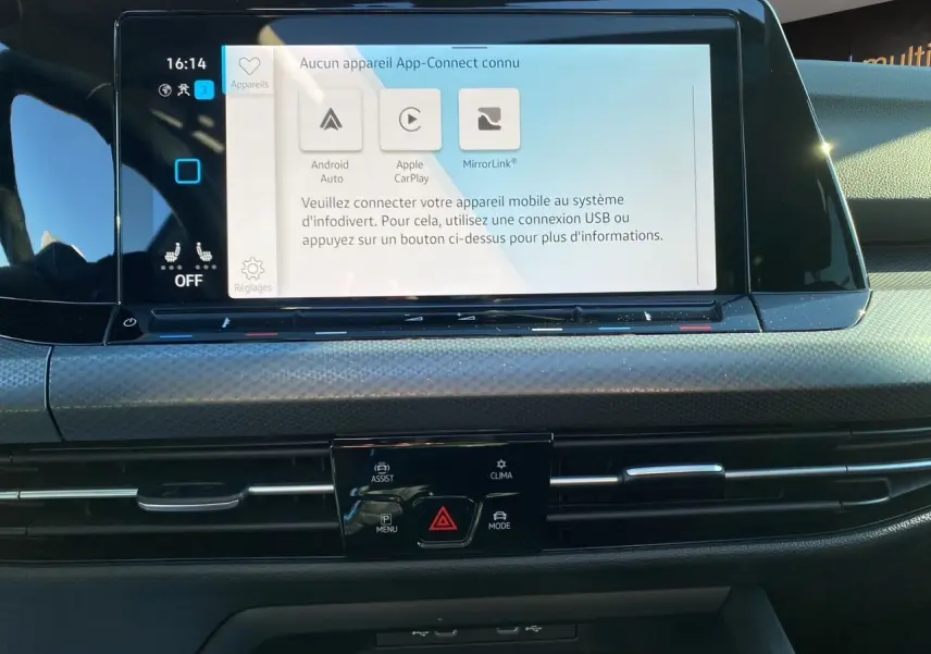 Vue rapprochée de l’écran tactile central et de la console de la Volkswagen Golf VIII noire avec commandes climatisation et connectivité smartphone.
