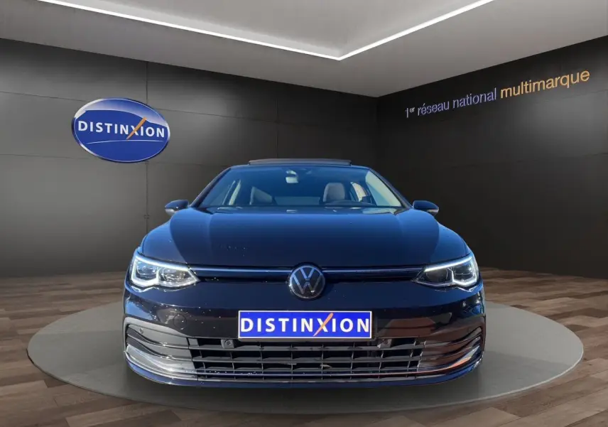 Volkswagen Golf VIII noire vue de face avec toit panoramique et projecteurs Matrix LED allumés.