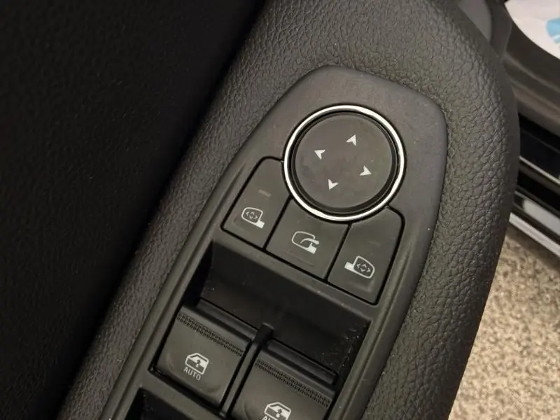 Détail des commandes de réglage des rétroviseurs et des vitres côté conducteur d'une Renault Clio V noire de 2025.