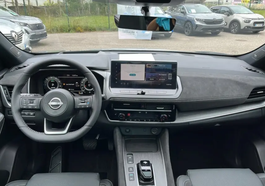 Vue intérieure frontale du Nissan Qashqai E-POWER 205 Tekna Plus 2026, tableau de bord moderne avec écran tactile et volant cuir multifonctions.