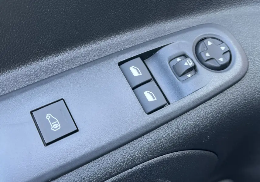 Boutons de commande des vitres et rétroviseurs sur la porte côté conducteur d'un Toyota Proace City blanc glacier 2023.