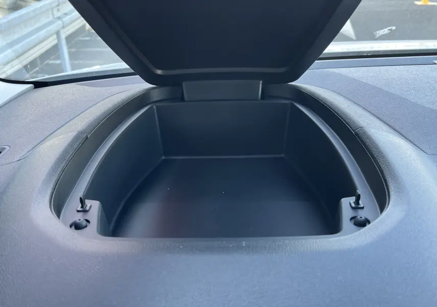 Rangement ouvert sur le tableau de bord du Toyota Proace City blanc glacier, vue intérieure en plongée.