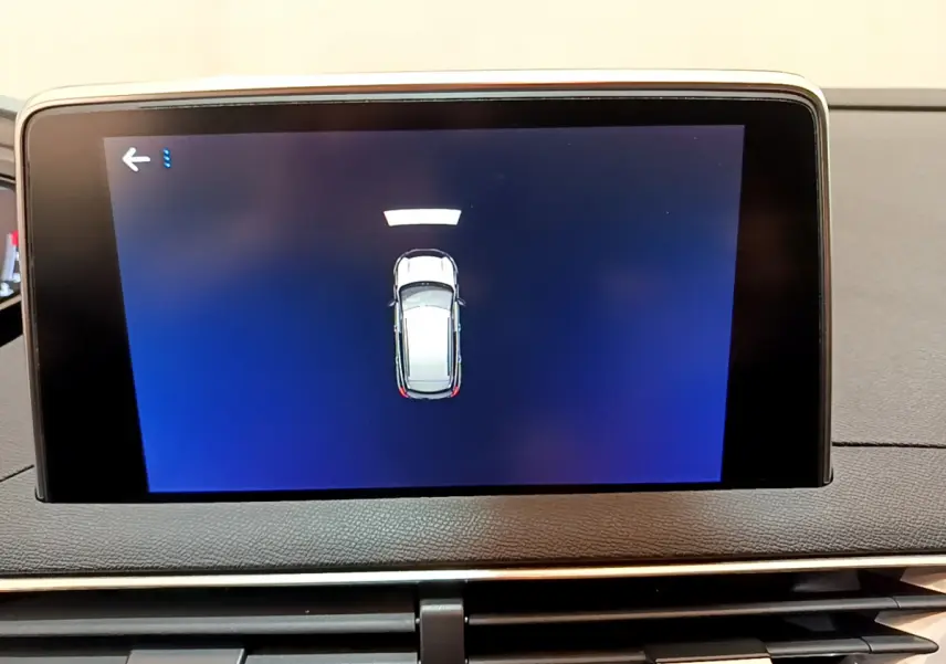 Écran tactile central du Peugeot 3008 noir de 2019 montrant l'alerte de proximité du véhicule en stationnement.