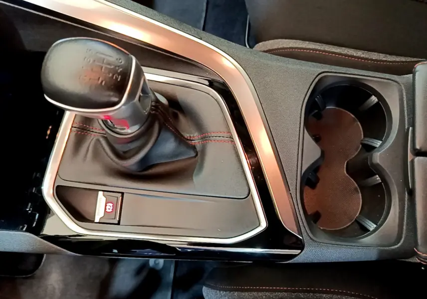 Gros plan sur la console centrale du Peugeot 3008 noir, mettant en valeur le levier de vitesse manuel et les porte-gobelets.