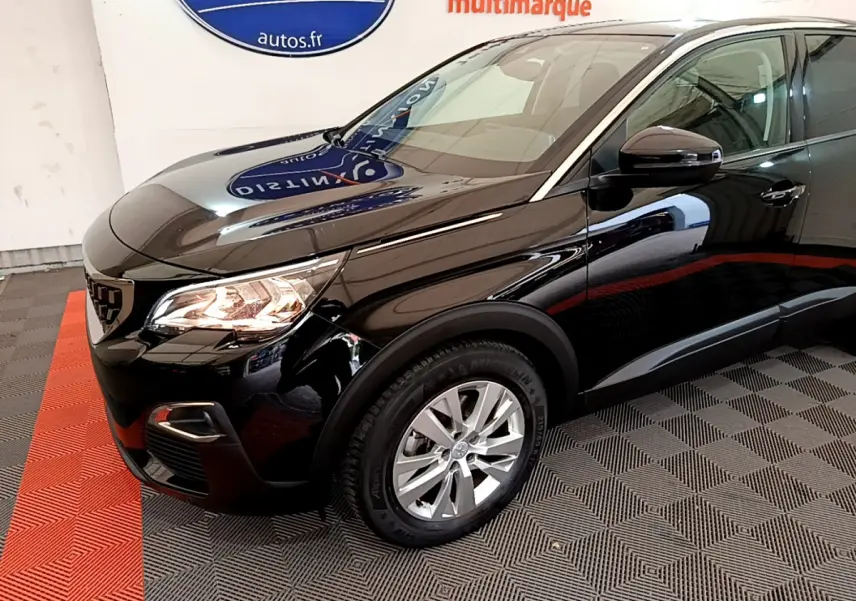 Vue 3/4 avant droit d'un Peugeot 3008 noir brillant avec phares allumés et jantes argentées sur sol carrelé.