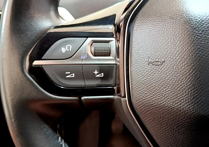 Gros plan sur les commandes gauche du volant cuir noir du Peugeot 3008 2019 version BlueHDi Active Business.